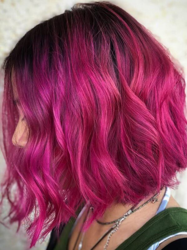 A modern long bob that enhances the depth of pink red hair 