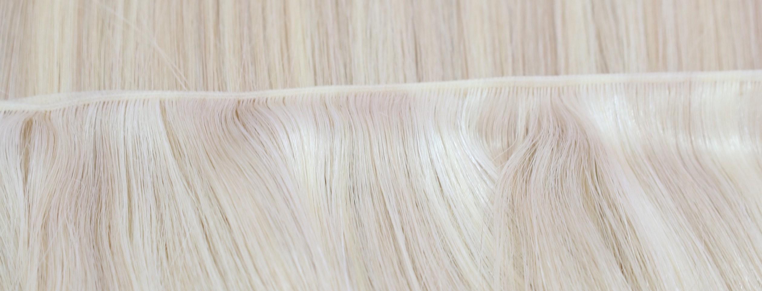 Blonde Vietnamese Remy hair sewn into a weft, seen up close