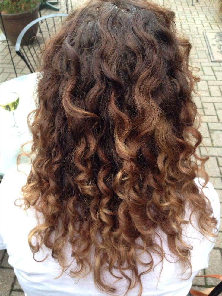 Dark brown curly hair with caramel highlights