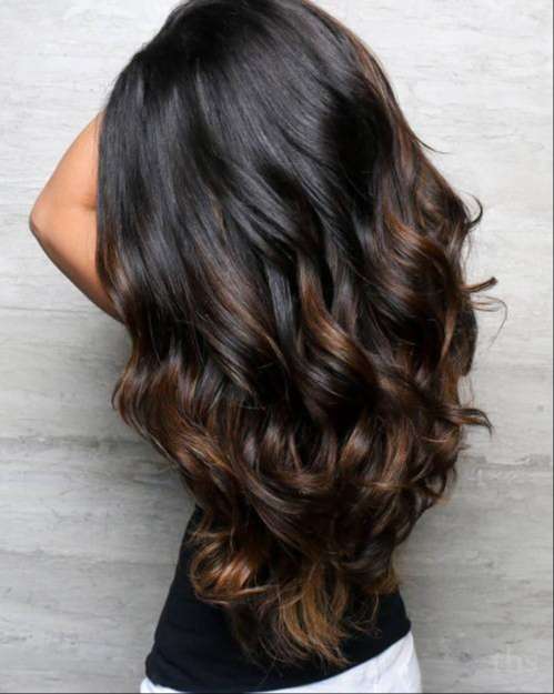Long dark brown hair with caramel highlights in wavy texture