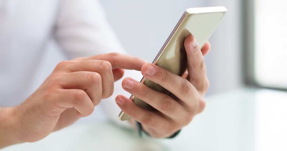 Hands tapping a phone to message Luxshine