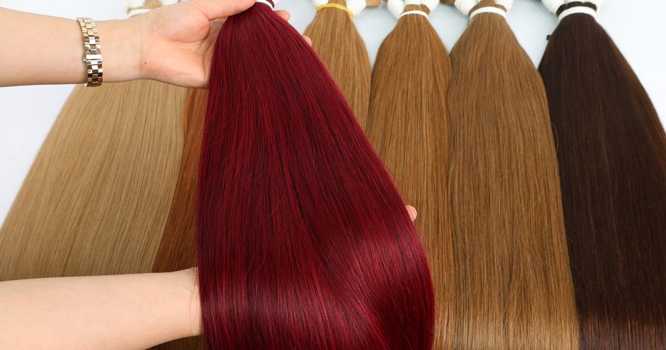 Bundles of hair in red, copper and brown shades held up for comparison
