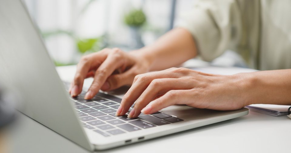 Hands typing on a laptop to track a delivery