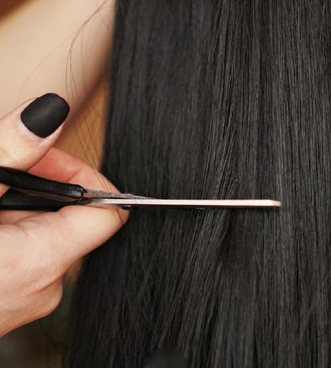 Raw Vietnamese hair being trimmed with scissors