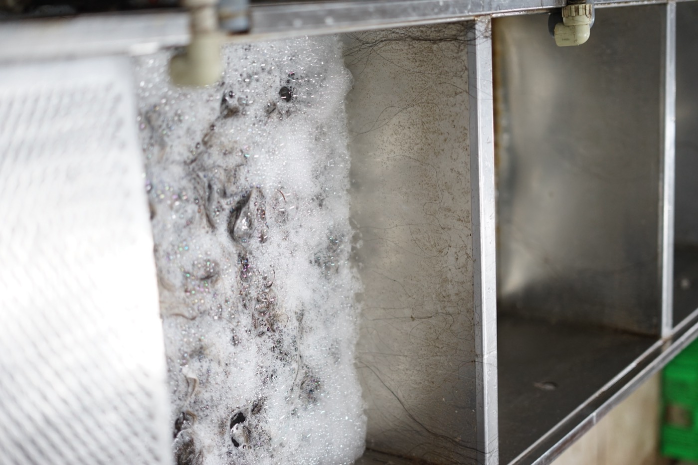 Hair being washed in a stainless steel tank